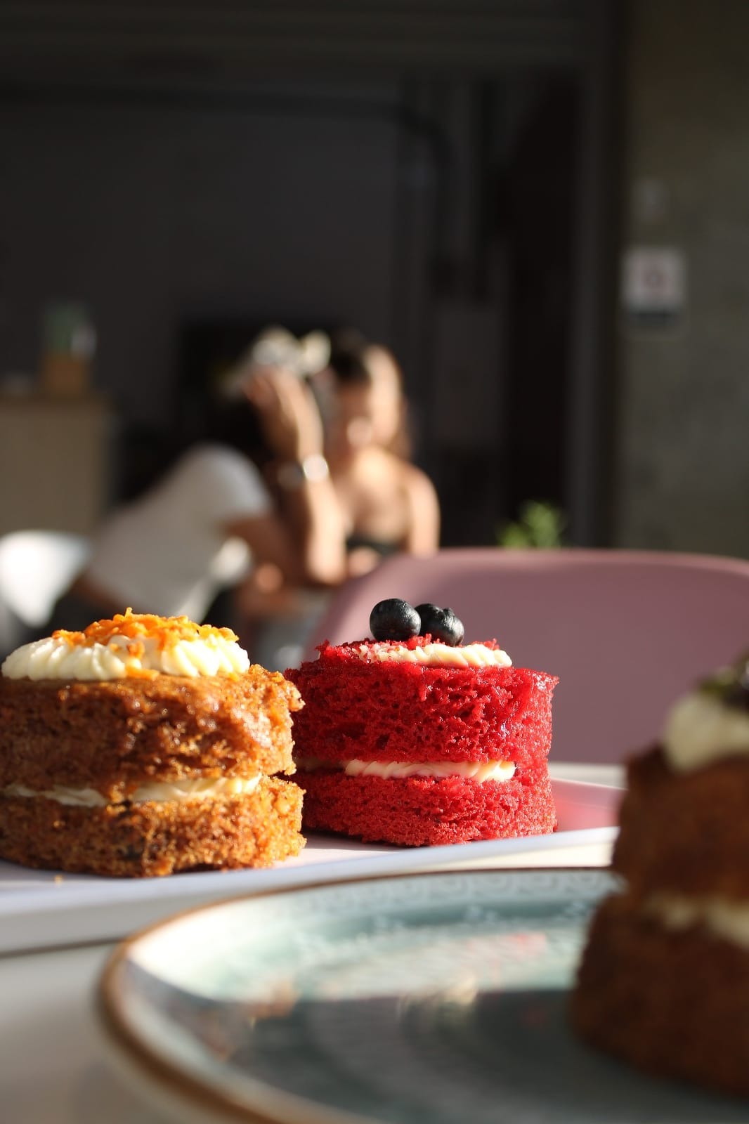 Tortas artesanales de zanahoria y red velvet de Celestial, sobre platos blancos en el café